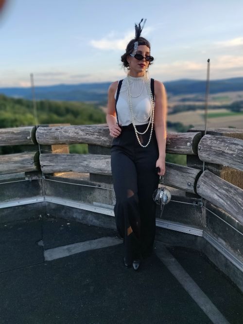 Gina Bley standing on top of a platform wearing a roaring 20s inspired outfit