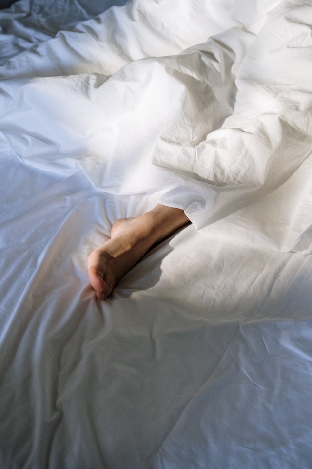 Image for the article "Why Sleep is the Foundation of Change" shows a foot peeking out from white bed sheets