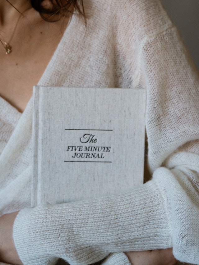 Image for the article "The Power of Journaling for Personal Insight" shows a woman holding a journal called "The 5 Minute Journal"