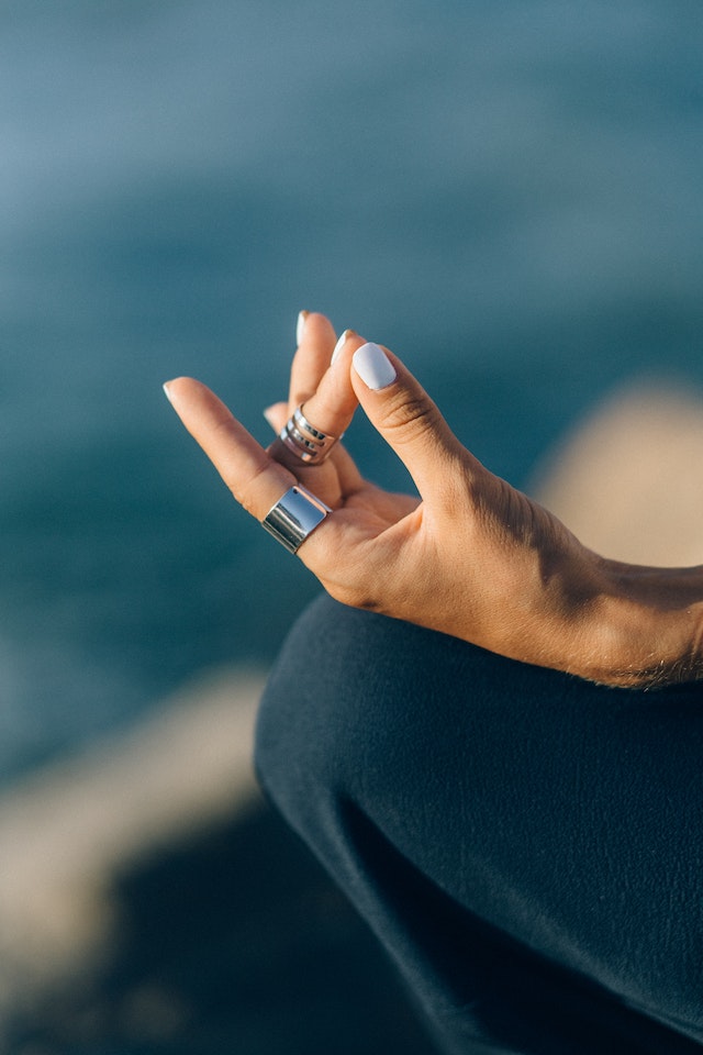 Image for the article "Daily Routines of Successful People" shows a close-up of a hand thumb to index finger for meditation